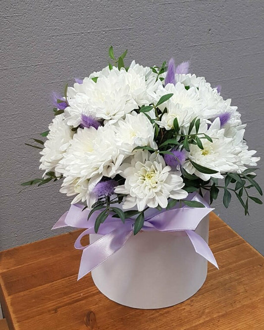A box with a white bush chrysanthemum and a "present" lagurus